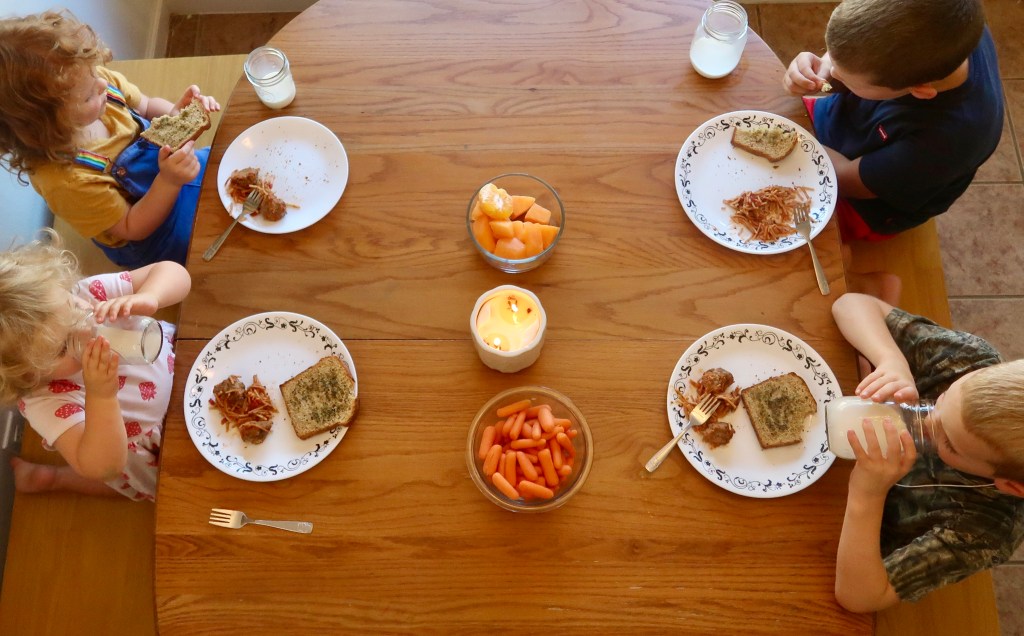 Children gathered around the dinner table, enjoying a homemade family meal and everyday moments of contentment
