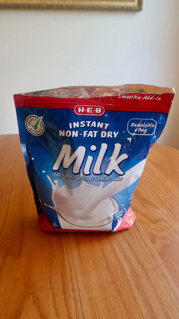 Package of H-E-B Instant Non-Fat Dry Milk, fortified with vitamins, featuring a resealable bag design.
