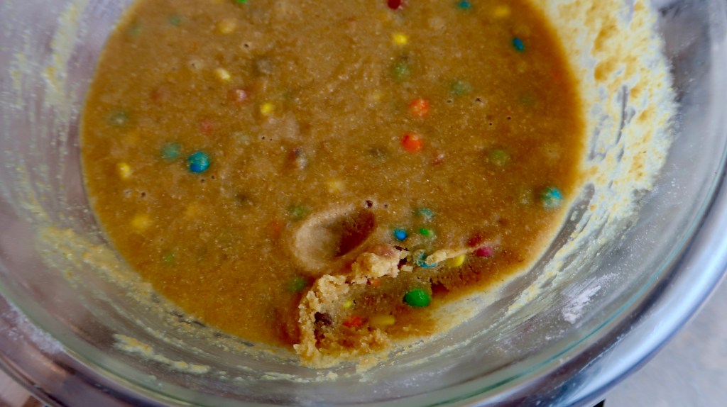 Bowl of cookie dough with colorful candy bits mixed in.